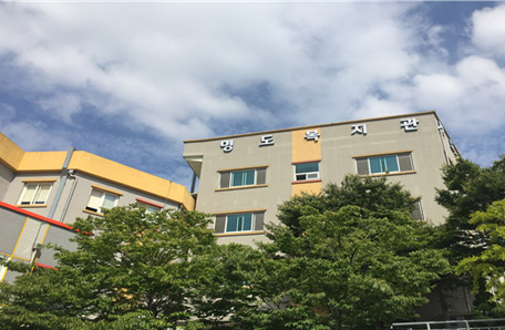 나무 위로 보이는 명도복지관 건물