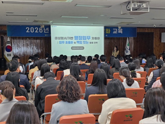 생성형AI기반 행정업무 자동화:업무 효율화 및 책임 있는 활용 전략 문구가 적힌 화면이 스크린에 띄워져있고, 여성 교육자가 스크린 앞에 서있다. 교육을 듣기 위해 앉아있는 교육자들의 뒷모습이 보인다.
