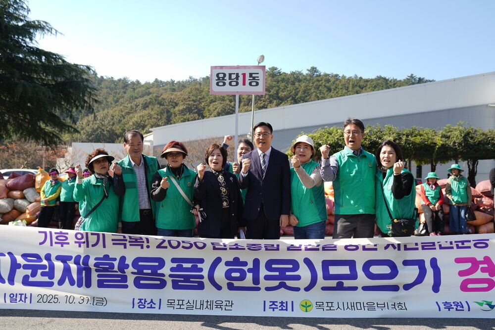 '기후 위기 극복! 2050 탄소중립 실현을 향한 시민실천운동 자원재활용품(헌옷) 모으기 경진대회' 현수막 뒤에서 '용당1동' 표지판을 들고 기념 촬영을 하는 사람들.